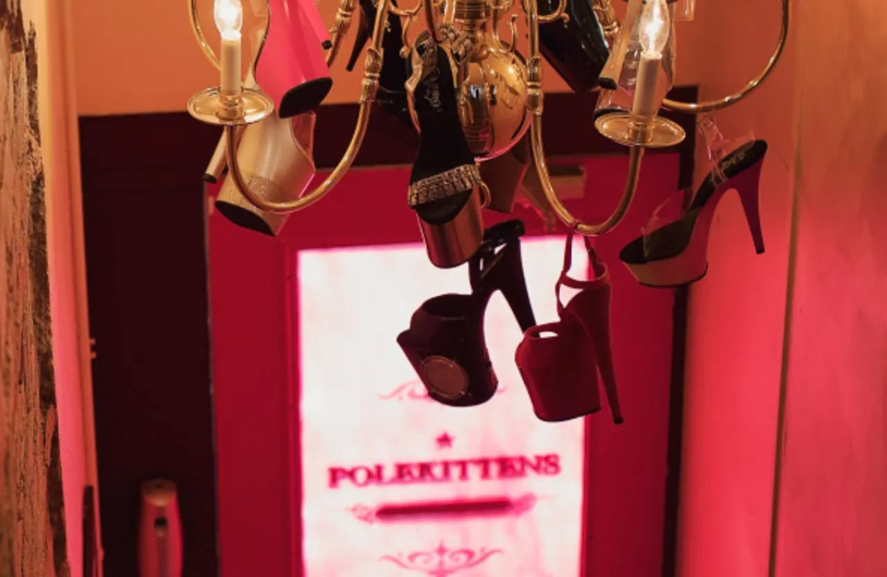 PoleKittens stairwell with gold chandelier and dangling heels