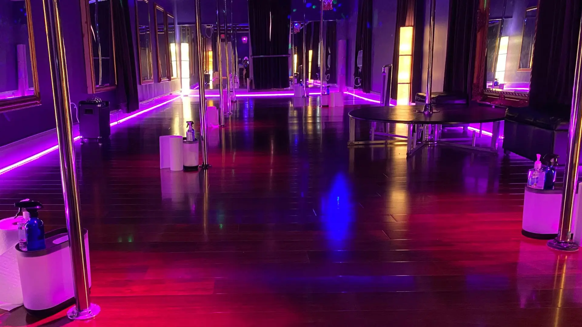 Inside the PoleKittens Fitness studio in Cincinnati — eight poles, boudoir lighting, gold-framed mirrors